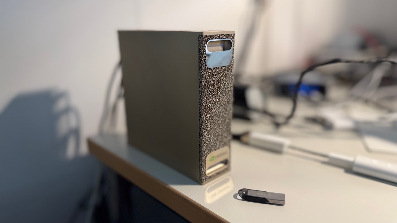 NVIDIA DGX Spark auf einem Tisch mit angeschlossenen Kabeln und USB-Stick
